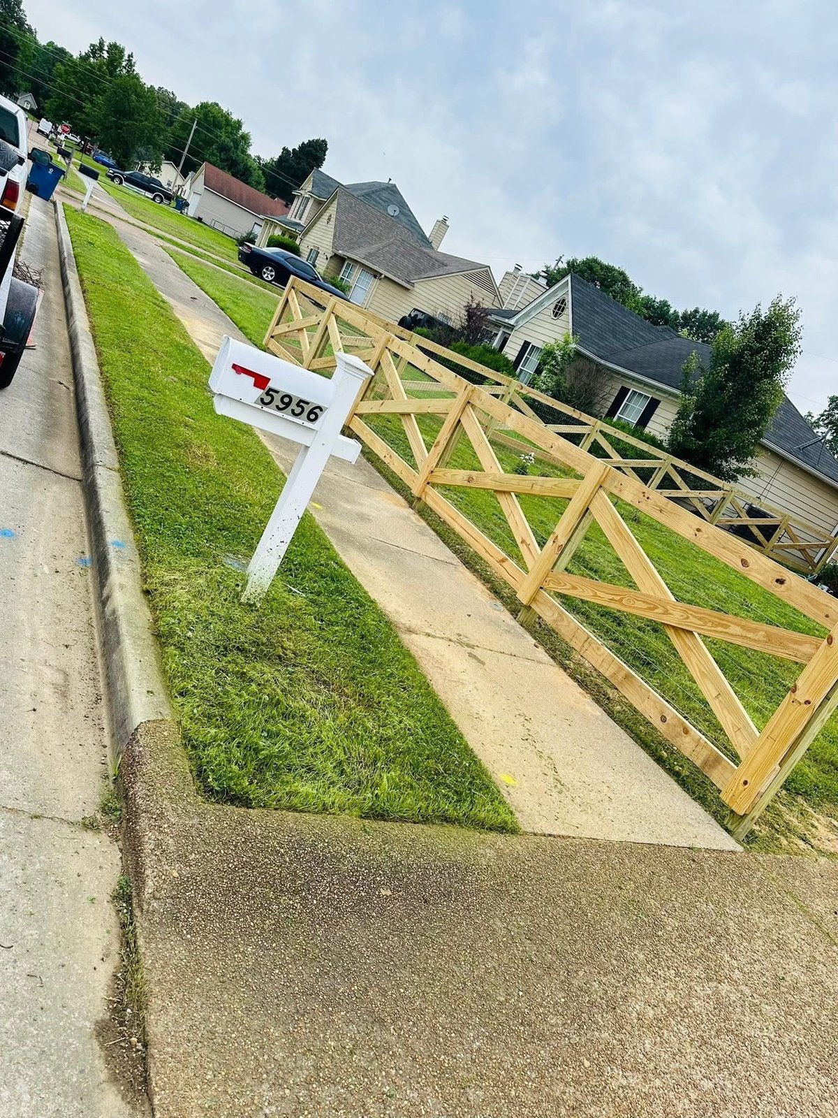 Wooden ranch-style privacy fence with X-pattern gate in a residential back yard
